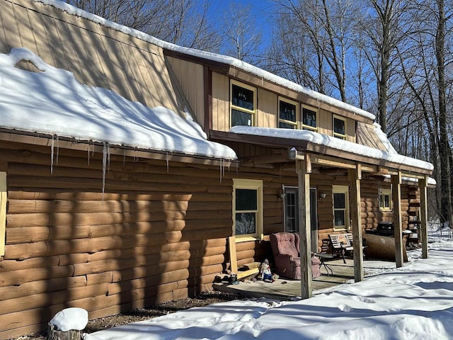 snow covered house with log exterior