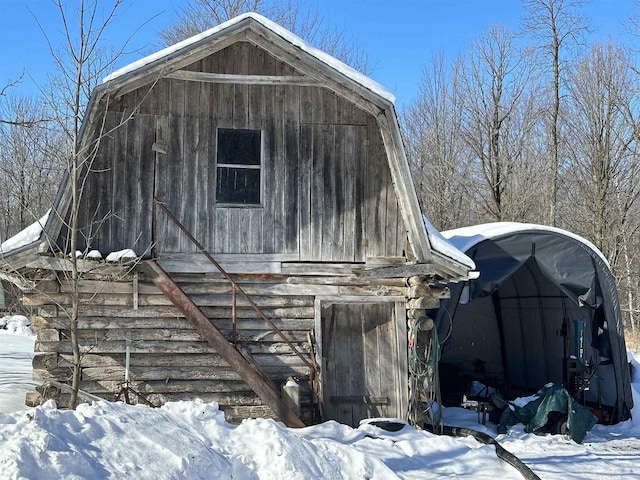 snow covered structure with a barn and an outdoor structure