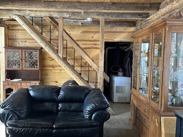 living room with wood walls, beamed ceiling, and stairs