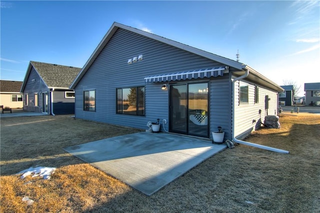 back of property with a patio area and a lawn