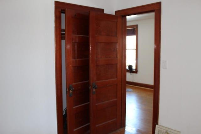 hallway featuring baseboards and wood finished floors