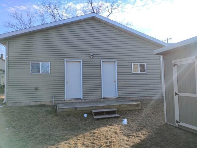 back of house with a shed and an outdoor structure