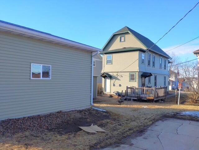 rear view of house featuring a wooden deck