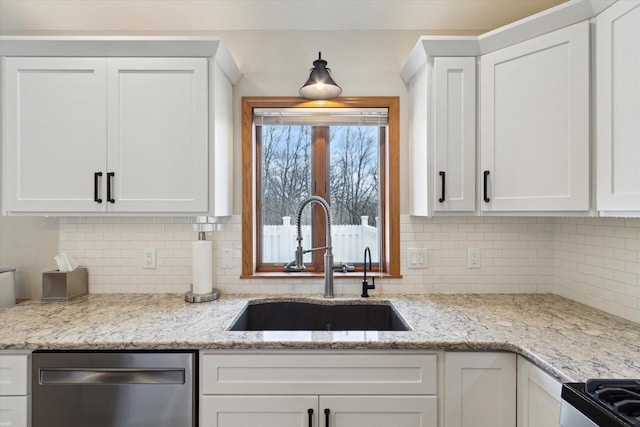 kitchen with a sink, white cabinetry, stainless steel dishwasher, light stone countertops, and tasteful backsplash