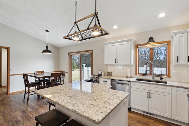 kitchen with visible vents, dark wood finished floors, white cabinets, lofted ceiling, and a sink