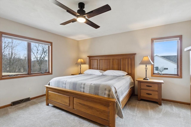 bedroom with baseboards, visible vents, ceiling fan, and light colored carpet