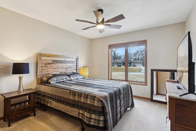 bedroom featuring light carpet, baseboards, and a ceiling fan