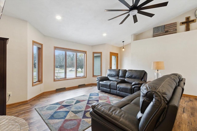 living area featuring lofted ceiling, visible vents, and wood finished floors