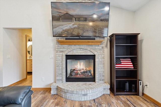 details with a brick fireplace, baseboards, and wood finished floors