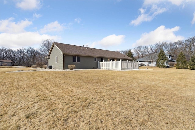 back of house with a lawn and fence