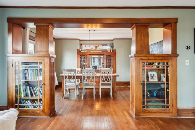 dining space featuring ornamental molding, baseboards, and hardwood / wood-style flooring