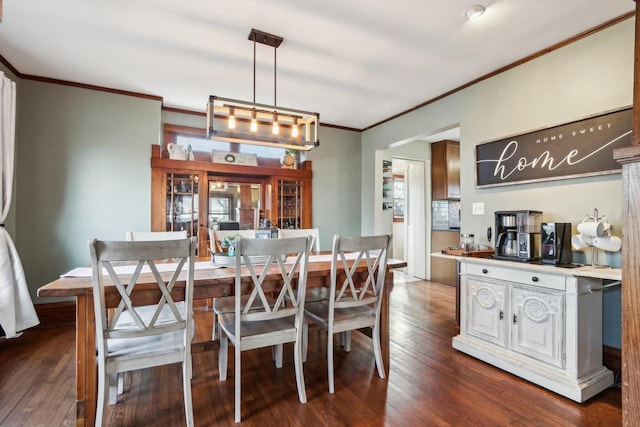 dining area featuring ornamental molding and dark wood-style flooring