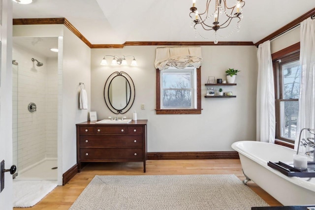 bathroom with baseboards, plenty of natural light, ornamental molding, and wood finished floors