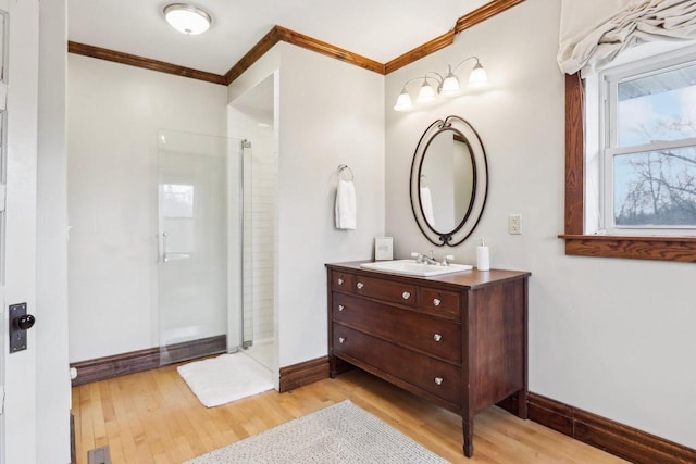 bathroom featuring walk in shower, crown molding, baseboards, and wood finished floors