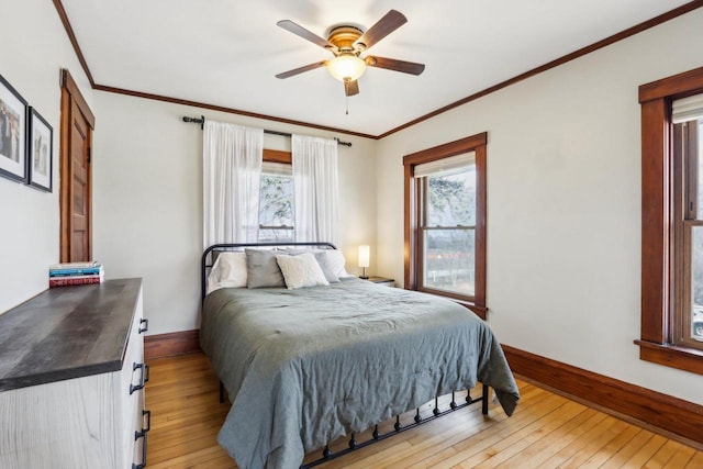 bedroom featuring light wood finished floors, multiple windows, and baseboards