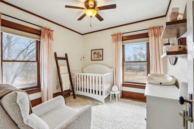 bedroom with ceiling fan, baseboards, crown molding, and carpet flooring