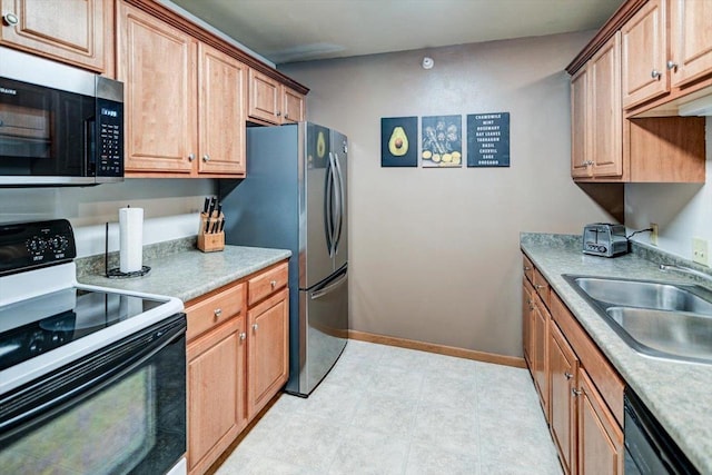 kitchen featuring a sink, baseboards, light countertops, brown cabinets, and black appliances