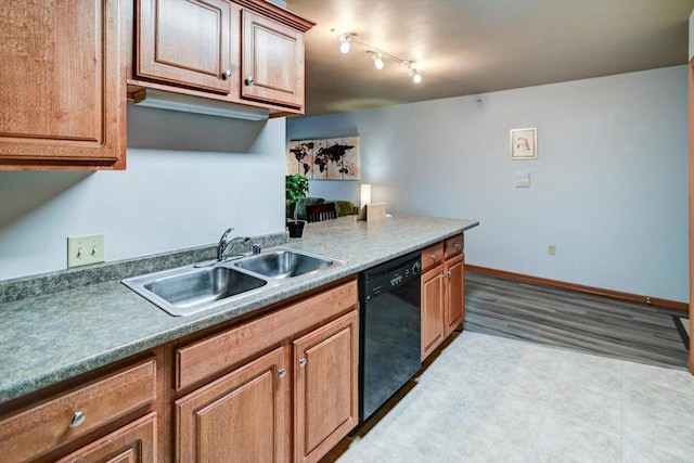 kitchen with brown cabinetry, black dishwasher, a sink, and baseboards