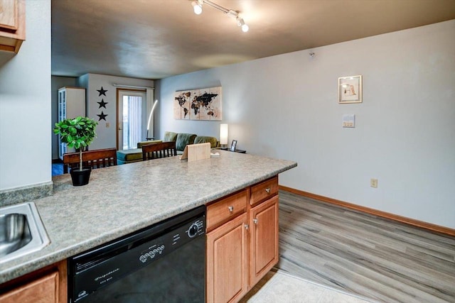 kitchen featuring baseboards, black dishwasher, light countertops, open floor plan, and light wood-style floors