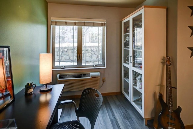 office area with baseboards, dark wood-type flooring, and an AC wall unit