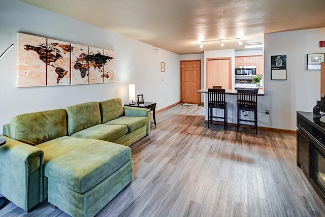 living room featuring light wood-type flooring and baseboards