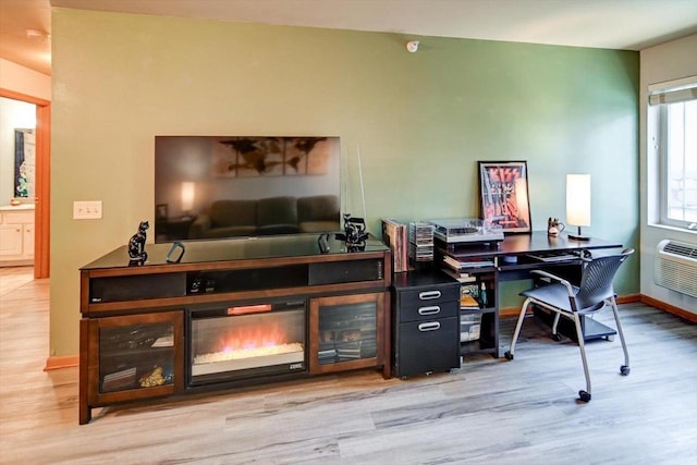 home office with light wood-style flooring and baseboards