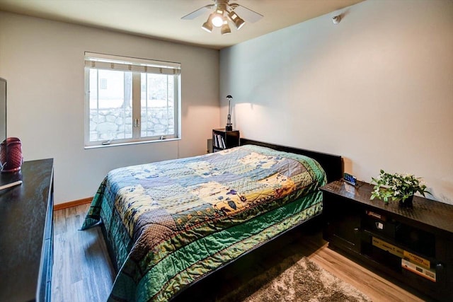 bedroom featuring light wood-style floors, ceiling fan, and baseboards