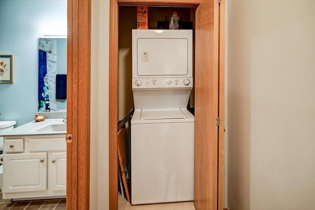 laundry room with laundry area, a sink, and stacked washer and clothes dryer