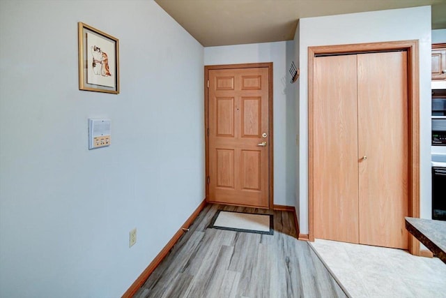 unfurnished bedroom with light wood finished floors, a closet, and baseboards