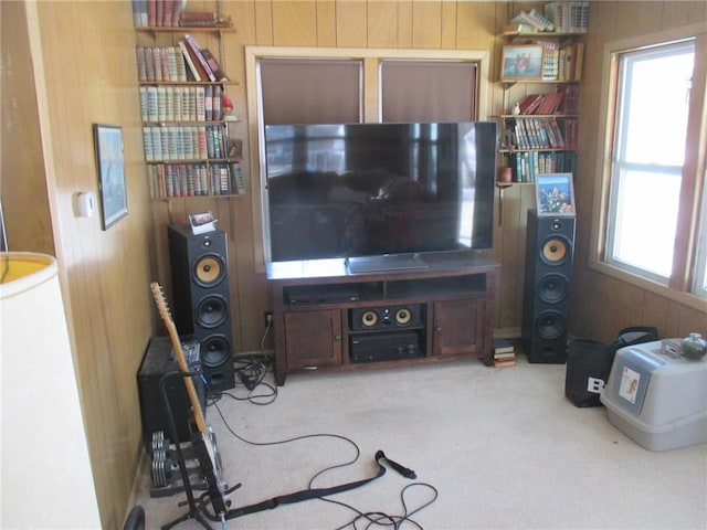 carpeted living room featuring wooden walls