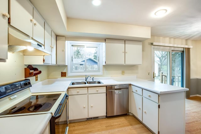 kitchen with range with electric cooktop, dishwasher, a peninsula, light wood-style floors, and a sink