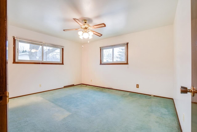 spare room with baseboards, carpet floors, ceiling fan, and a healthy amount of sunlight