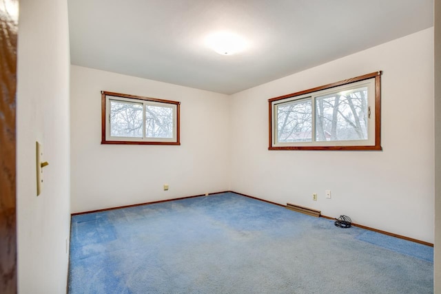 carpeted spare room featuring plenty of natural light and baseboards