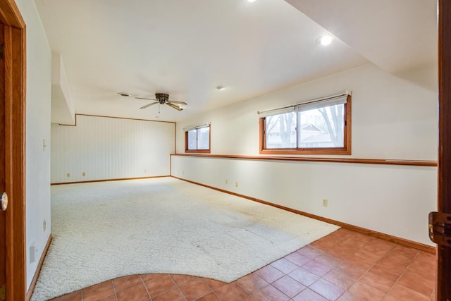 carpeted empty room with ceiling fan and baseboards