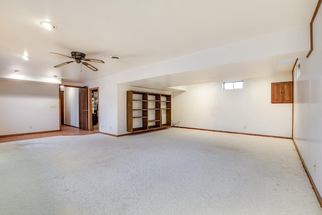 empty room featuring light carpet, ceiling fan, visible vents, and baseboards