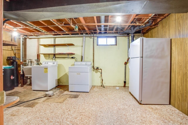 clothes washing area featuring laundry area, wooden walls, and washer and dryer