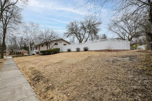 view of side of home featuring fence