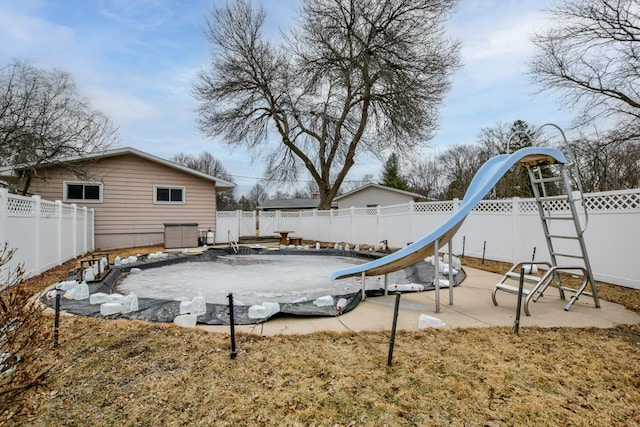 view of playground with a fenced backyard and a patio