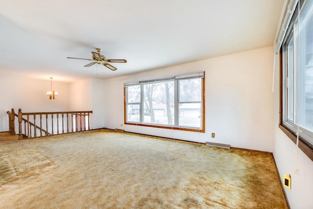 carpeted empty room with visible vents and ceiling fan with notable chandelier