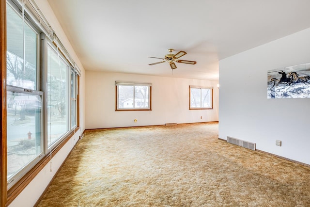 unfurnished room featuring carpet, visible vents, ceiling fan, and baseboards