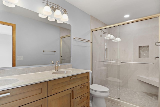 full bath featuring a stall shower, a sink, toilet, and double vanity