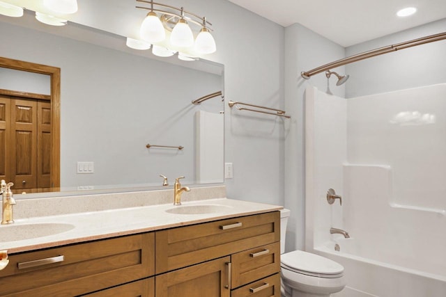 bathroom with toilet, double vanity, a sink, and bathing tub / shower combination