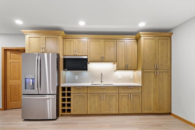 kitchen with light wood-style flooring, a sink, light countertops, backsplash, and stainless steel fridge with ice dispenser