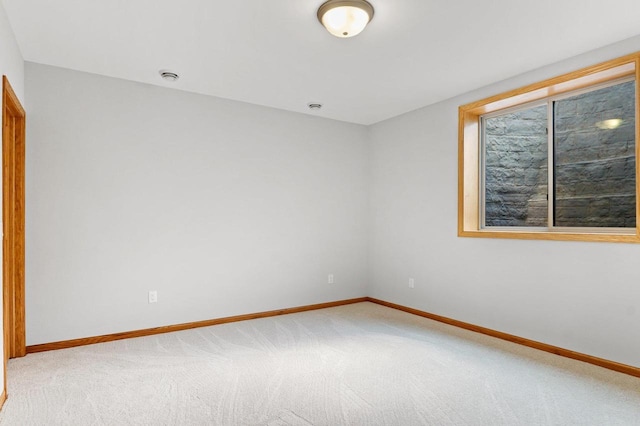 unfurnished room with light carpet and baseboards