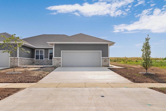 view of front of home featuring stone siding, concrete driveway, roof with shingles, and an attached garage