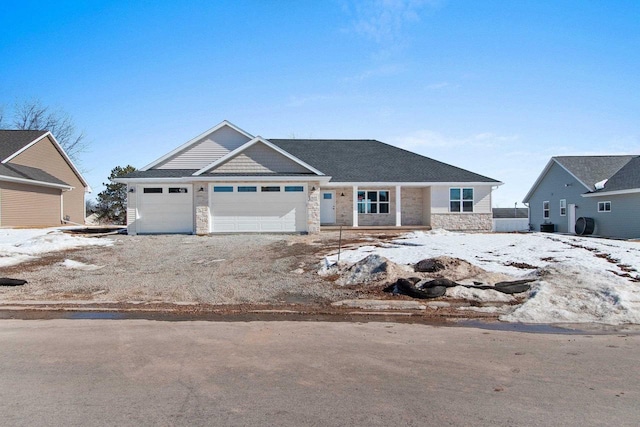 view of front of home featuring a garage, stone siding, and driveway