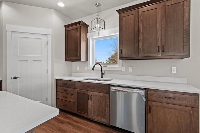 kitchen featuring light countertops, stainless steel dishwasher, a sink, and pendant lighting