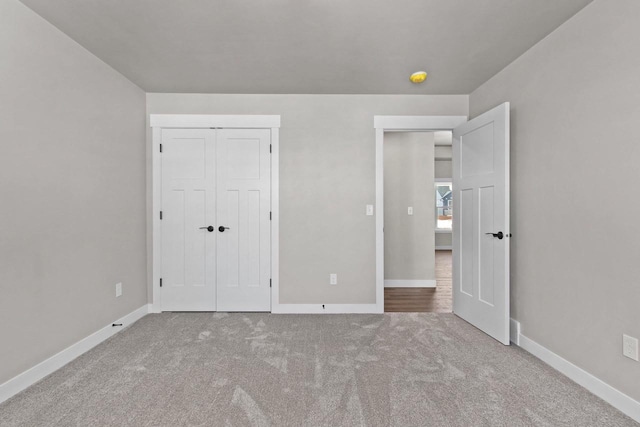 unfurnished bedroom with a closet, carpet flooring, and baseboards