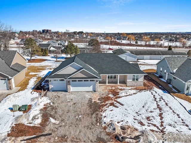 snowy aerial view with a residential view