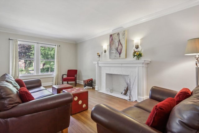 living room with baseboards, ornamental molding, a fireplace with flush hearth, and light wood-style floors